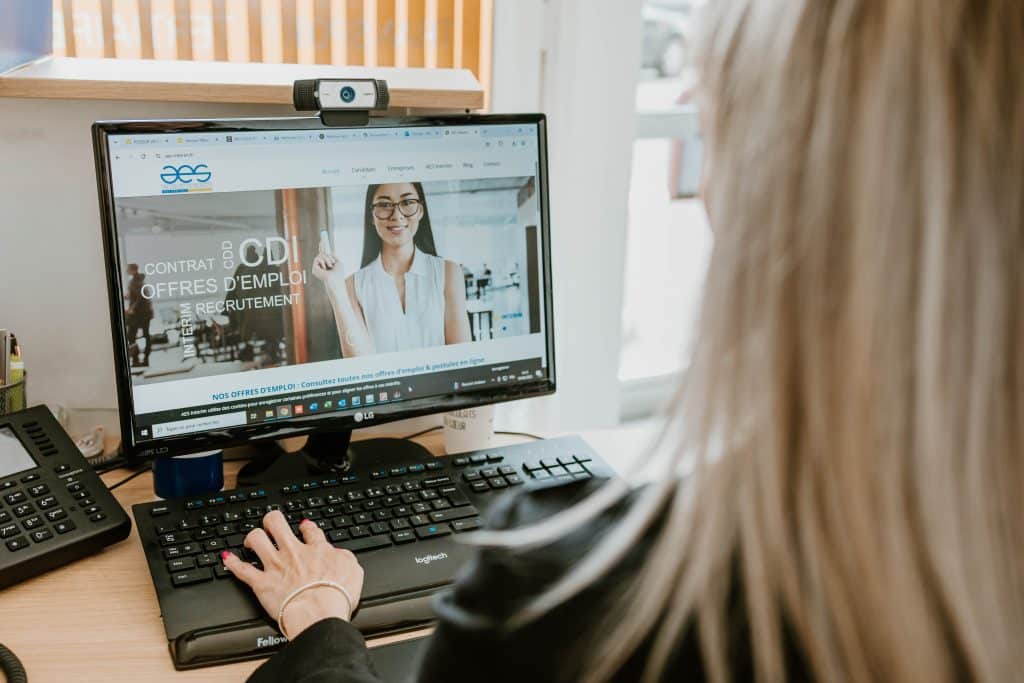 Conseillère de l'agence AES Intérim travaillant sur le site internet depuis son bureau